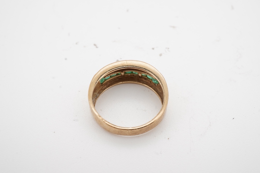 An emerald and diamond half hoop ring, channel-set to the front with calibré-cut emeralds, between lines of brilliant-cut diamonds, mounted in gold, size J, gross weight approximately 2.5 grams